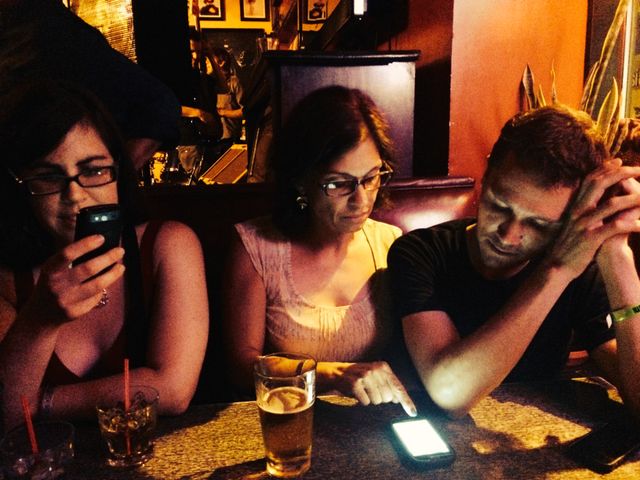 Sondra and Robin and Dan looking at schedules in a restaurant booth